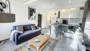 Un appartement moderne comprenant un salon, une cuisine et un coin repas.