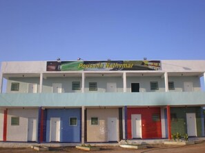 Un edificio con un letrero que dice "Pousada Nathymar" y varias habitaciones con puertas.