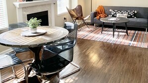 Ein modernes Wohnzimmer mit Kamin, einem runden Esstisch und einer Couch.