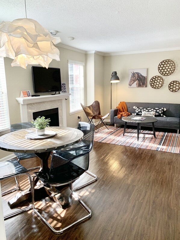 Un salon moderne avec une cheminée, une table à manger ronde et un canapé.