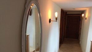A hallway with a large mirror and wall-mounted lights. - Apartment Ida up to 6 people (Stuer)