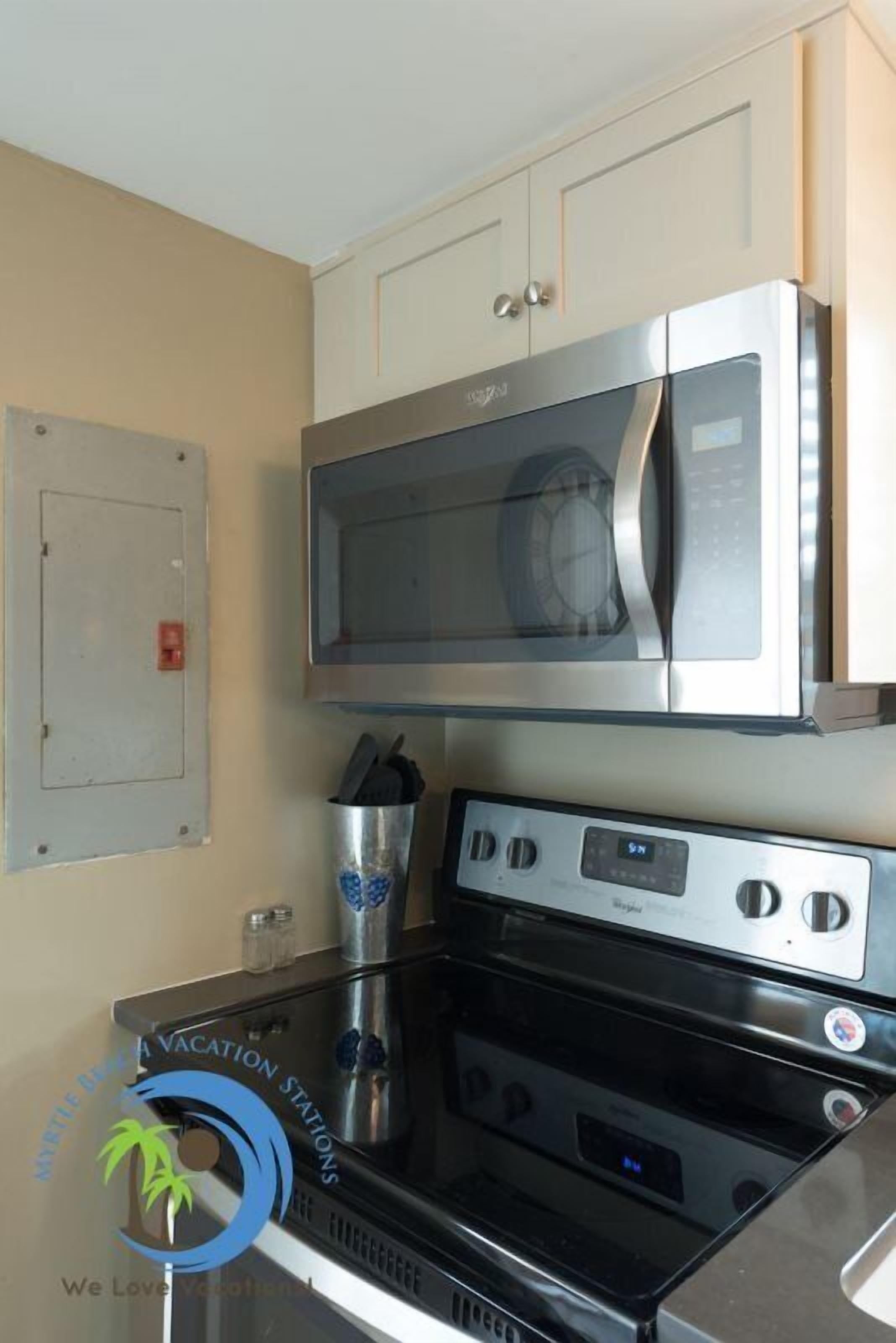 A kitchen with a microwave, stove, and cabinets.
