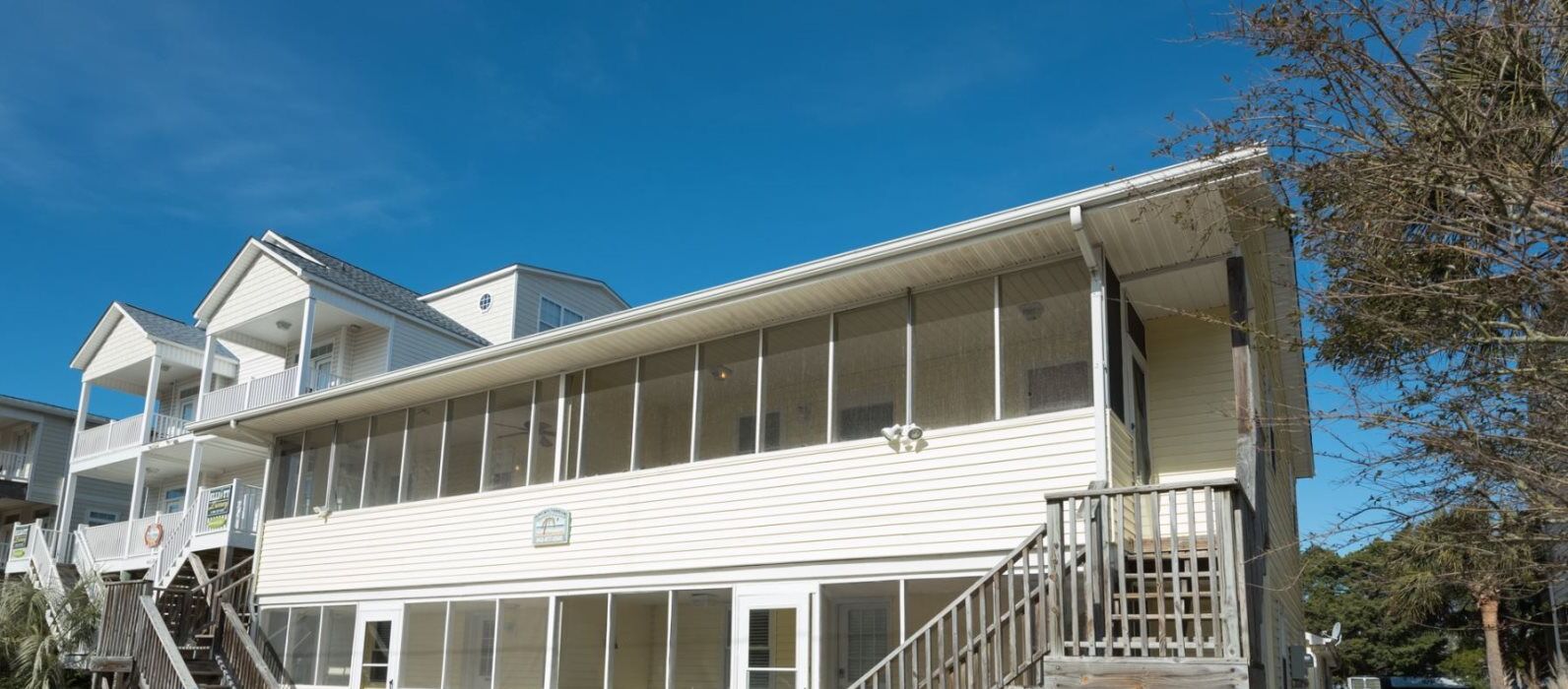 A two-story building with a wooden staircase leading to a balcony.