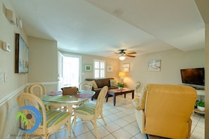 A spacious living area with a dining table, chairs, a sofa, a TV, and a ceiling fan. - Windy Hill Villa 4 - Beach Fun (North Myrtle Beach)