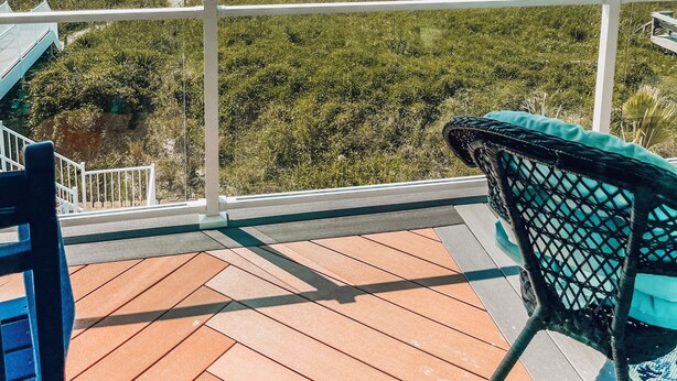 A balcony with a view of the beach, a wooden deck, and a chair. - "Be Still" - Oceanfront Home w/ Private Pool, 4 Bedrooms / 3.5 Bathrooms (Holden Beach)