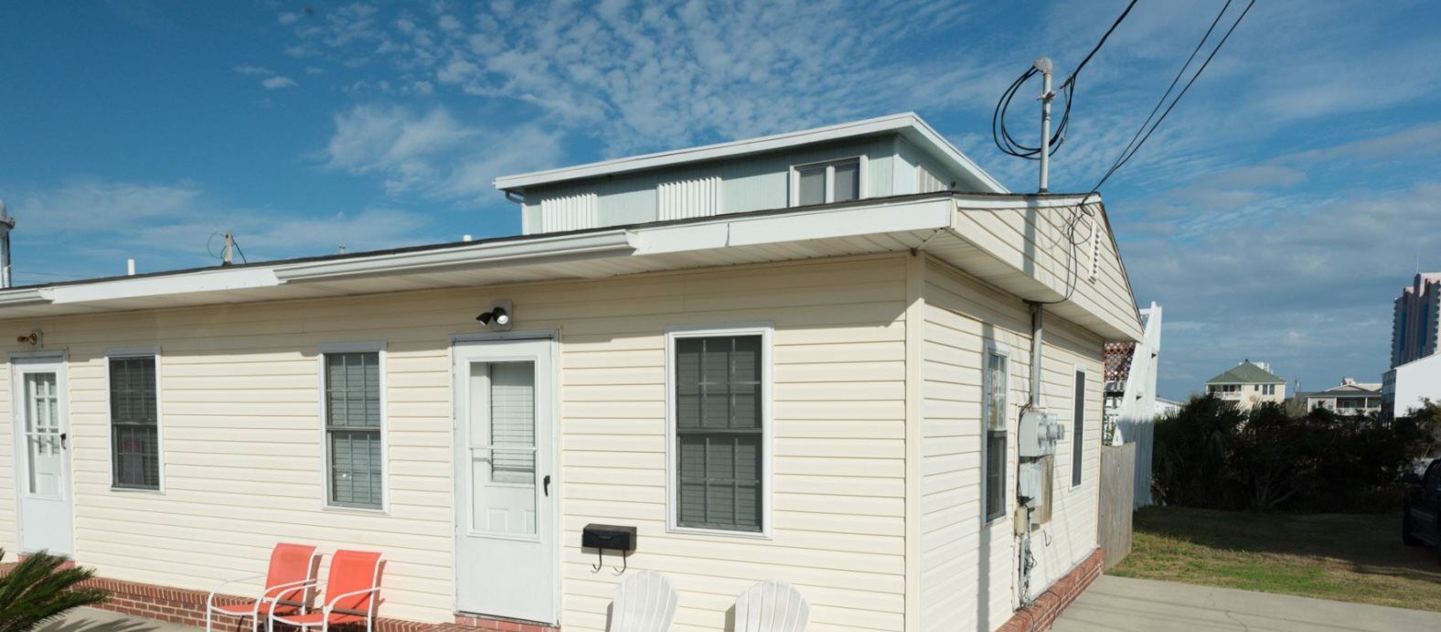 A single-story house with a front porch, a small attached garage, and a satellite dish.