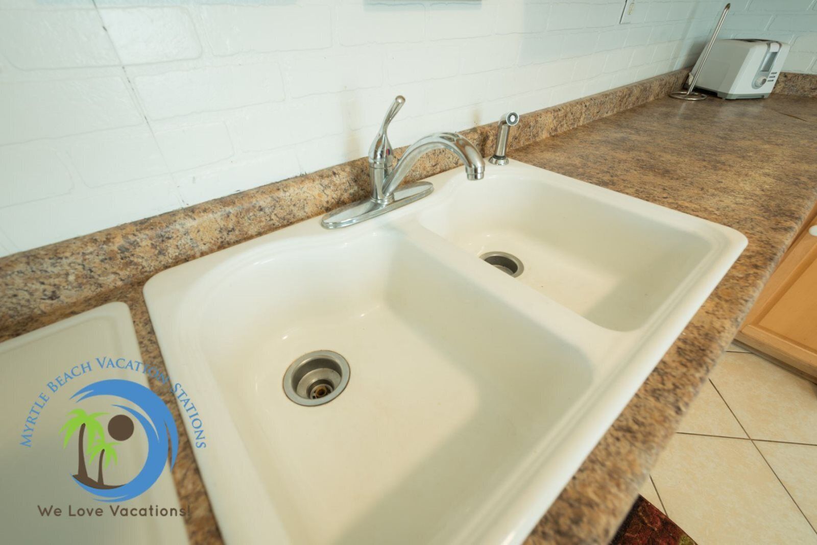 A white kitchen sink with a single faucet and a drain.