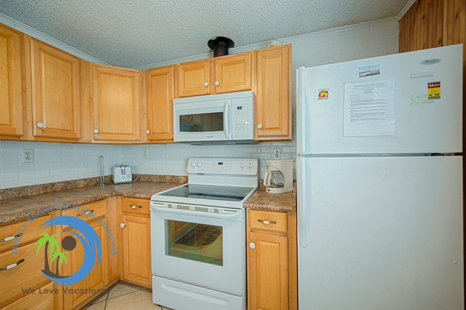 A kitchen with wooden cabinets, a microwave, a stove, and a refrigerator.