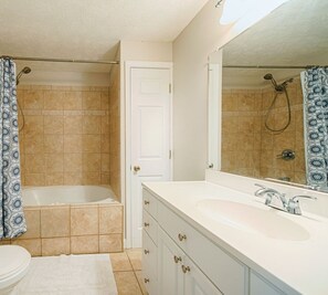 A bathroom with a bathtub, a shower, a sink, and a mirror. - CG Cottage Up (North Myrtle Beach)