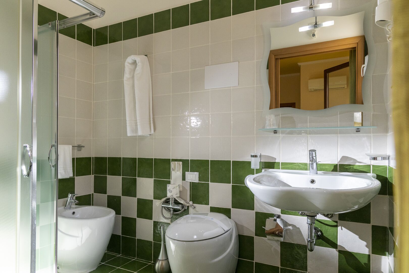 Un bagno con due lavandini, un water e una doccia.