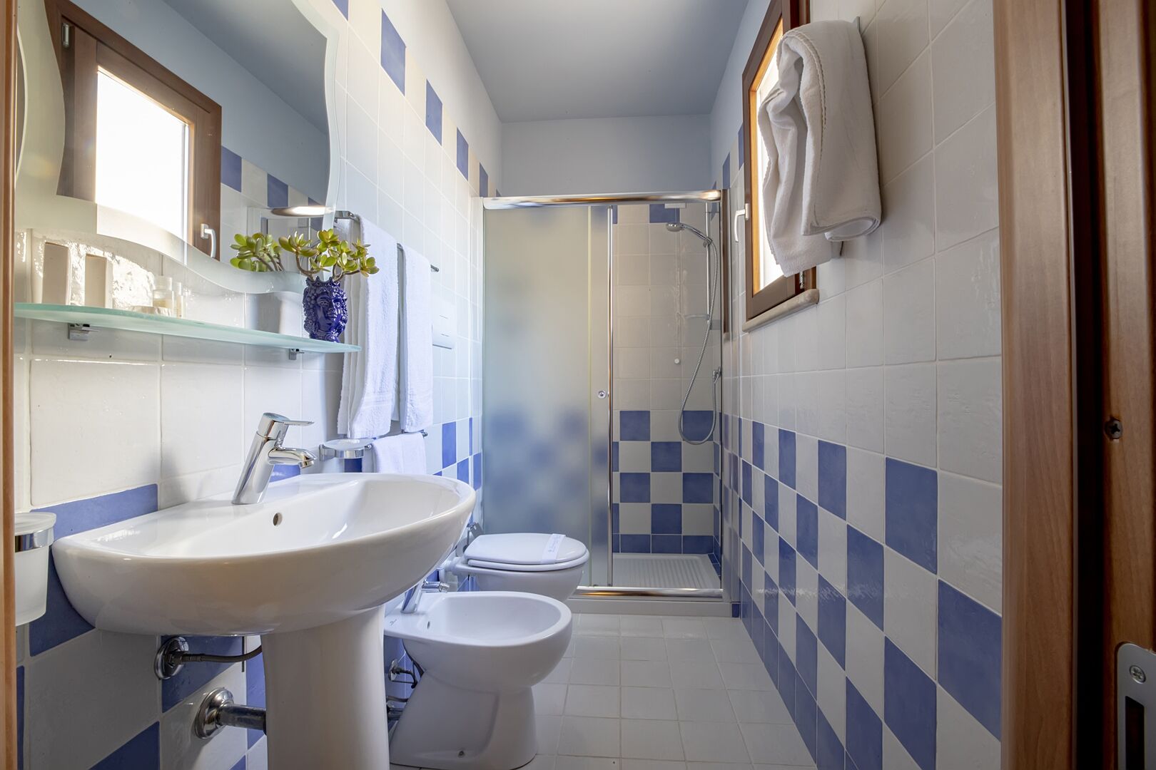 Un baño con lavamanos, inodoro y zona de ducha.