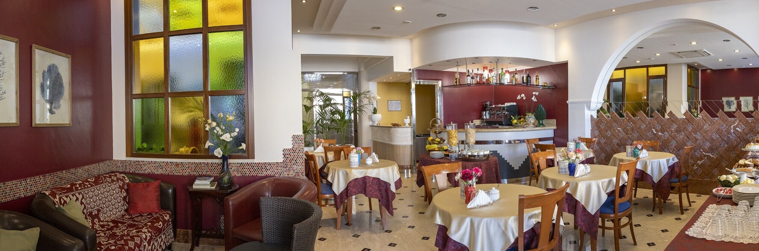 A restaurant with round tables, chairs, and a bar area.