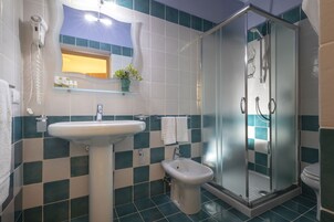 Un baño con lavamanos, bidé y ducha.
