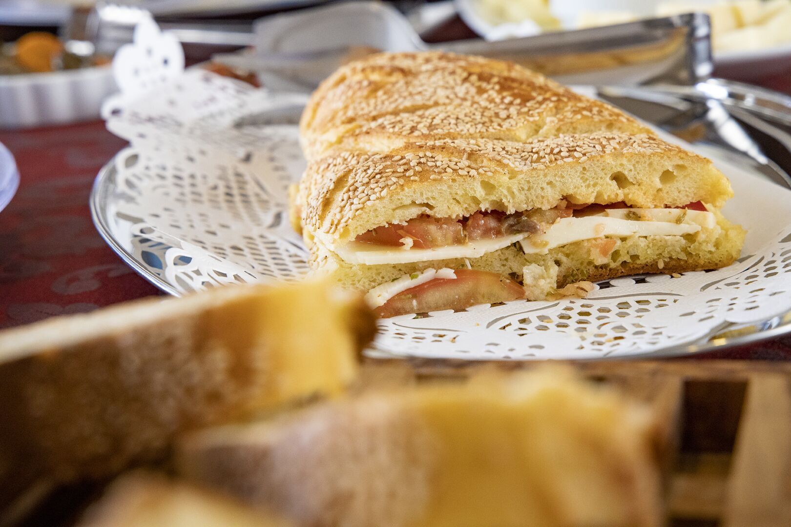 Un panino su un piatto con un sottotavola in pizzo.