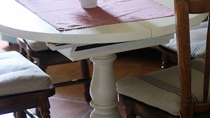 A dining table with a vase of flowers, a placemat, and a sign with the word "EAT" and some text. - Half-timbered house Dorothea up to 4 people (Stuer)