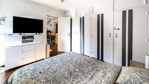 A bedroom with a bed, a TV, a wardrobe, and a ceiling fan. - Les Embruns - Appt 2 ch avec parking (Saint-Cyprien)