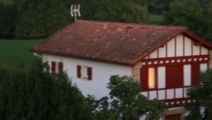 A traditional half-timbered house with a red-tiled roof, surrounded by greenery and a clear sky. - Chambres d'Hotes Ene Gutizia (Ustaritz)
