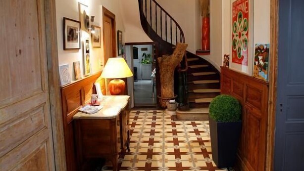 A hallway with a checkered floor, a wooden bench, a lamp, and a staircase leading to another level. - Chambres d'Hotes Ene Gutizia (Ustaritz)