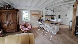 Una cocina amplia con armarios blancos, una mesa de comedor de madera y una isla integrada.