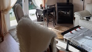 Una sala de estar acogedora con chimenea, una mesa de comedor y un espacio de estar confortable.