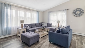 Ein modernes Wohnzimmer mit einer Eckcouch, einem Zweisitzer und einem Couchtisch.