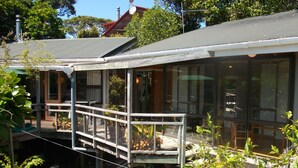 A modern house with a covered porch, large windows, and a small deck.