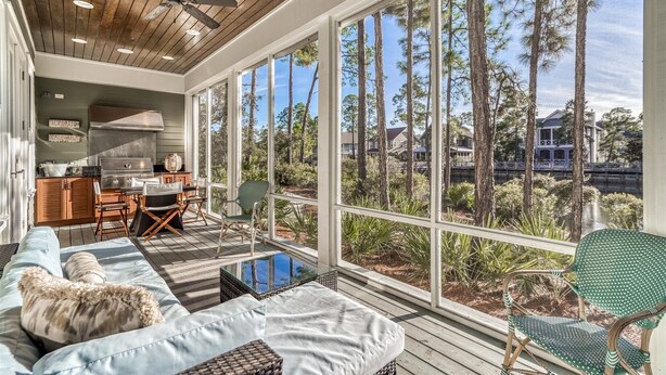 A spacious outdoor area with a wooden ceiling, large windows, and a view of tall trees and a body of water. - Exclusive Pet-Friendly Watersound West Beach Retreat with Electric Cart, Bikes, Pool & Beach Access (Santa Rosa Beach)