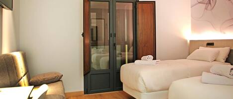 A hotel room with a bed, a desk, and a wardrobe.