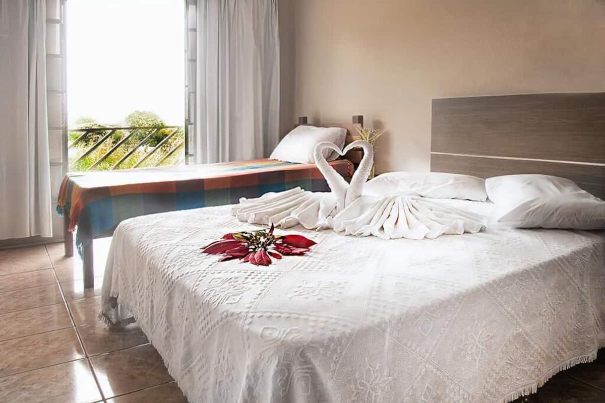 Ein Hotelzimmer mit Bett, Nachttisch und Blick ins Freie.