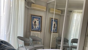 A bedroom with a large bed, two chairs, a mirror, and artwork on the wall. - Perfect location at Promenades des Anglais, with balcony and a sea view. (Nice)