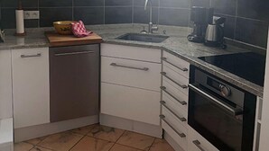 A compact kitchen with white cabinets, a built-in dishwasher, a stove, and a sink. - Perfect location at Promenades des Anglais, with balcony and a sea view. (Nice)