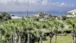 Uma área residencial à beira-mar, com casas, palmeiras e vista para o oceano.