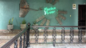 Una pared con un letrero de neón que dice "Monclova Mi amor" y un adorno metálico con una cadena rota.