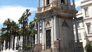 A historical tower with statues, surrounded by palm trees and buildings. - Oh Mamma Mia (Pompei)