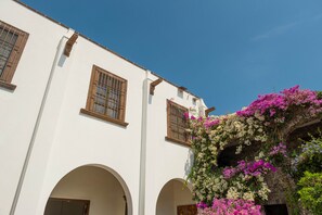 A white building with arched doorways and wooden window frames. - Hotel Layseca (San Juan del Río)