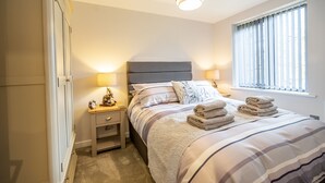 A neatly arranged bedroom with a bed, bedside lamps, a nightstand, and a wardrobe. - 14 St Johns Mews - sleeps 3 guests  in 1 bedroom (York)