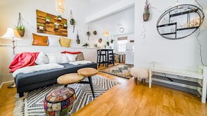 A modern living room with a sofa, round coffee table, and decorative rugs. - Downtown Cabin on Quiet Hilltop. Airy Deck & Views (Estes Park)