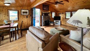 Een knus houten interieur met een stenen open haard, lederen meubels en een televisie.