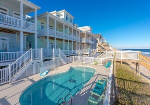 A multi-story hotel with a pool and a beach view.