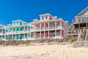 A beachfront property with multi-story buildings, balconies, and wooden walkways.