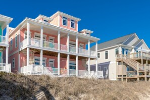 A beachfront property with multiple levels, balconies, and a wooden staircase. - Anchors Away - Stunning 5BR Oceanfront Home - Elevator, Comm. Pool (Surf City)