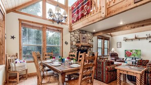 Een gezellig lodge met een stenen open haard, een houten eettafel en een comfortabele zithoek.