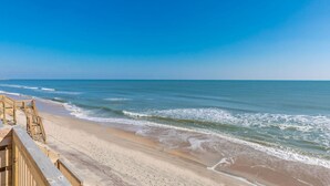 Una spiaggia con una passerella in legno che conduce all'acqua.