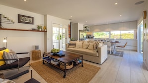 Un salon moderne comprenant un canapé, une table basse et un coin repas avec une table et des chaises.