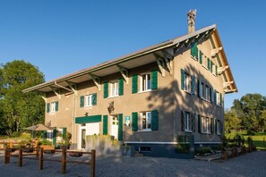 A two-story building with a sloped roof, green shutters, and a chimney. - Amodo Lodge - JARO Room (Saint-Paul-en-Chablais)