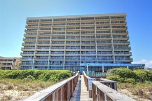 Een meerlaags hotel met een modern design, met balkons op elke verdieping.