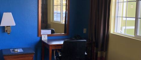 A room with a desk, chair, and a couch.