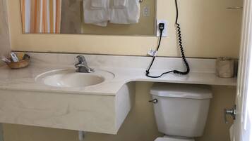A bathroom with a sink, mirror, towel rack, and toilet.