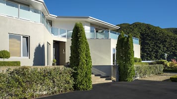Situated in a lush environment, this residence features a minimalist design with clean lines and large windows.