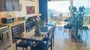 Une cuisine moderne avec un coin repas, un ventilateur de plafond et une vue sur l’océan.